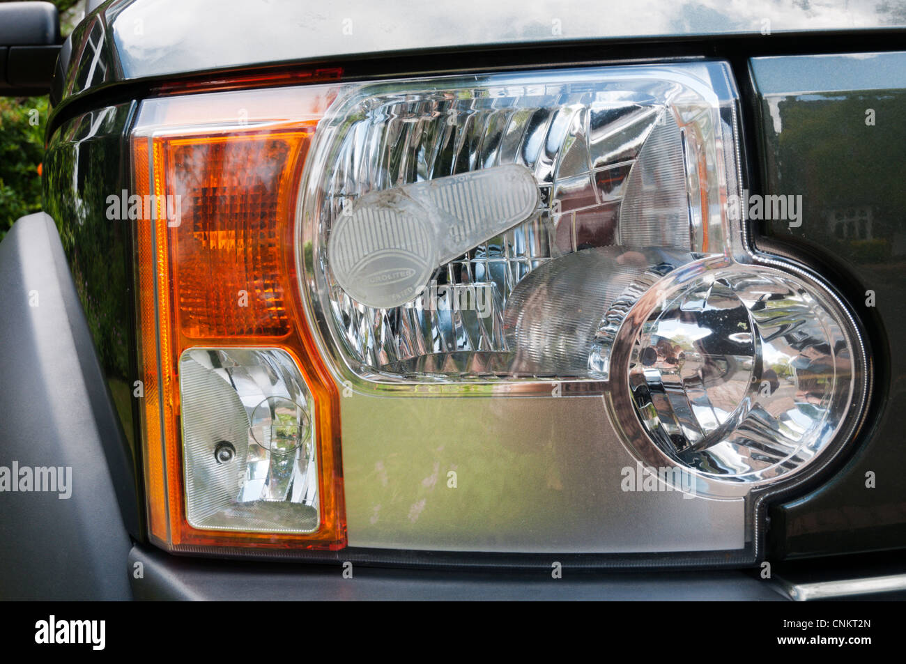 Deflettore di fascio montata al faro di fuorigioco di un Land Rover Discovery 3, per la guida sul lato destro della strada in Europa Foto Stock
