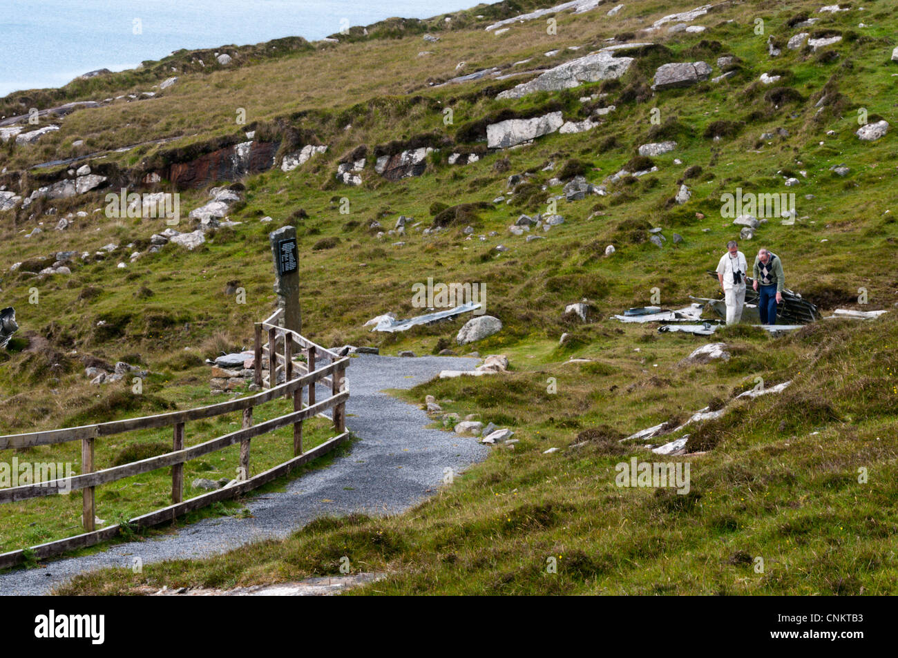 I turisti in un memoriale sulla Vatersay per le vittime e i sopravvissuti di un Catalina Flying Boat crash durante la seconda guerra mondiale nel 1944. Foto Stock