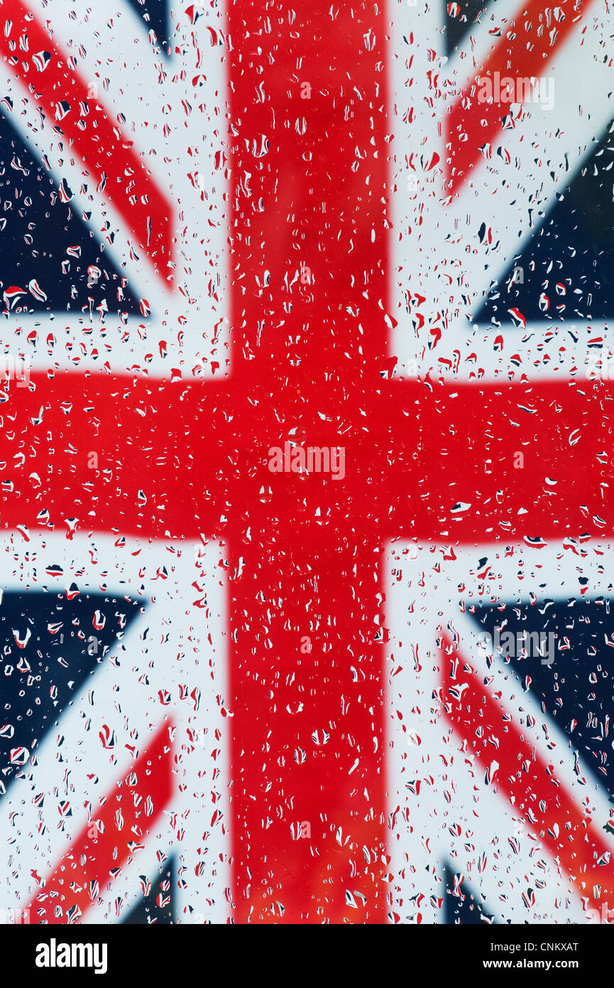 Le gocce di pioggia sul vetro di fronte a un'Unione jack flag Foto Stock