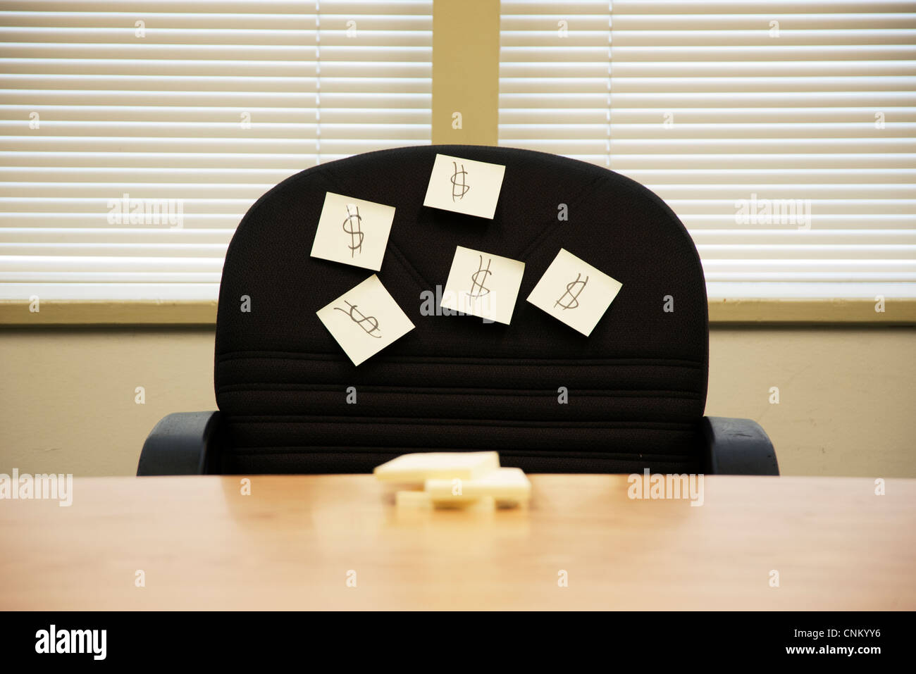 Sticky Notes con segni di dollaro sulla parte posteriore della sedia nella sala riunioni Foto Stock