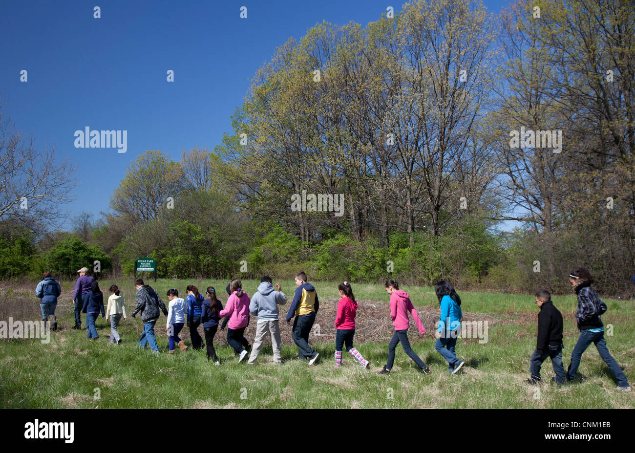 I bambini delle elementari preparare per seminare i semi per ripristinare un nativo di prateria dopo che esso è stato intenzionalmente bruciati. Foto Stock