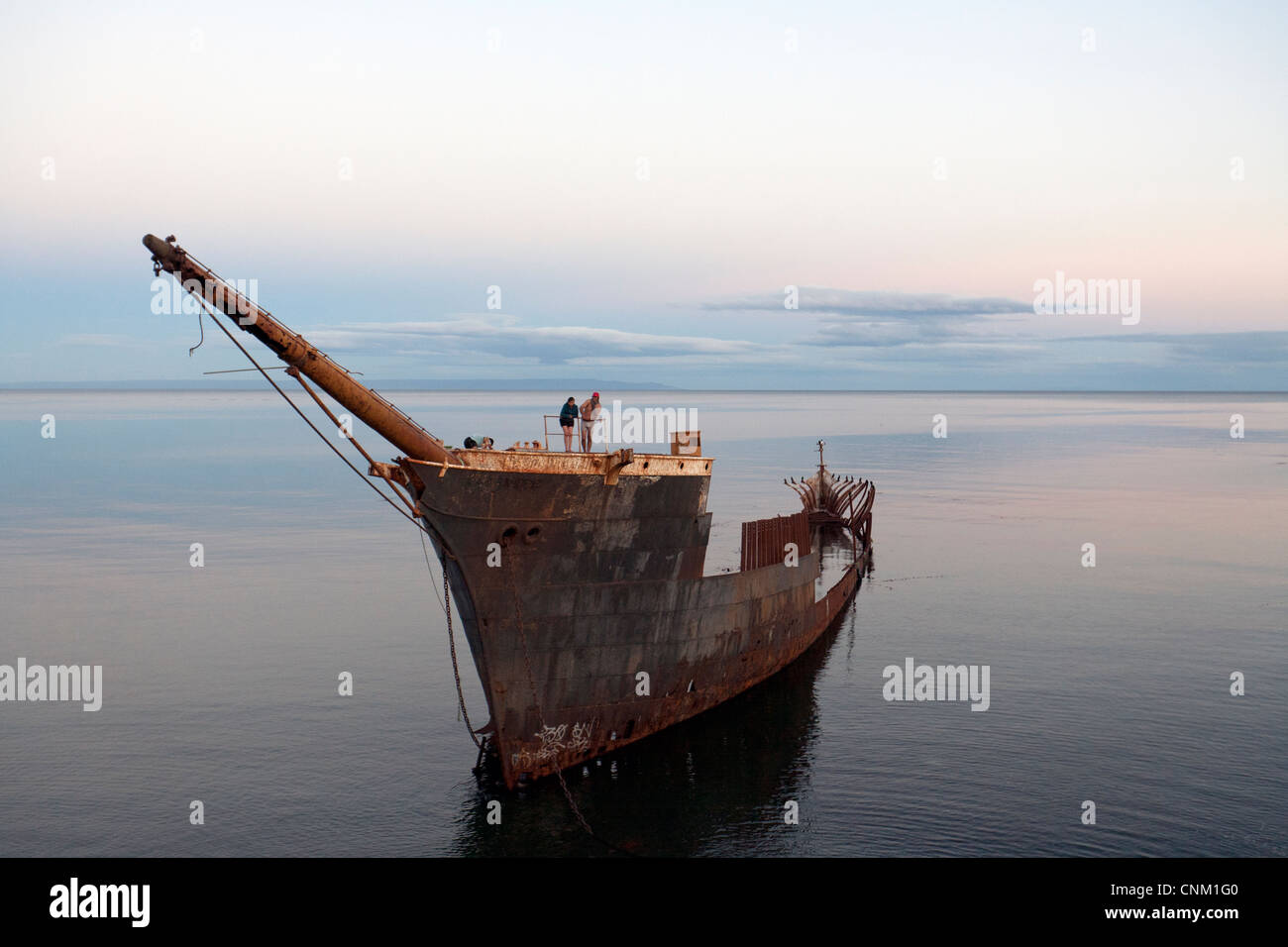 La gente sulla sommità di uno storico naufragata la nave abbandonata in costa Punta Arenas, Patagonia cilena, Cile Foto Stock