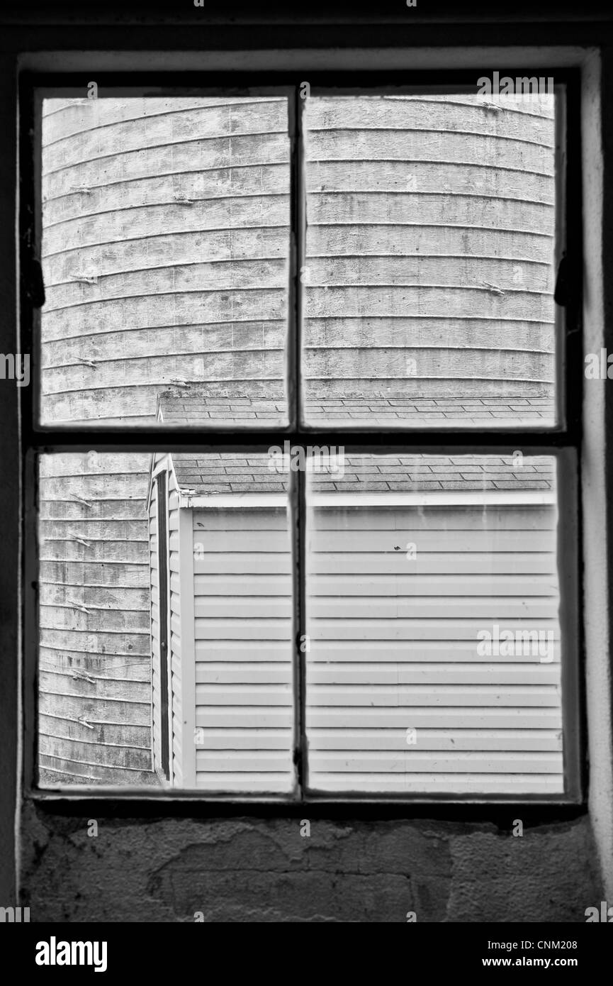 Lato di un silo attraverso un vetro di finestra di un caseificio Foto Stock