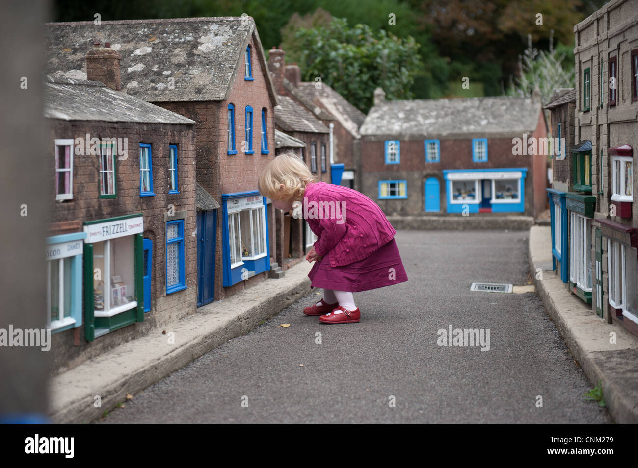 Una bambina si aggira intorno le strade di Wimborne Model Village a Wimborne, Dorset Foto Stock