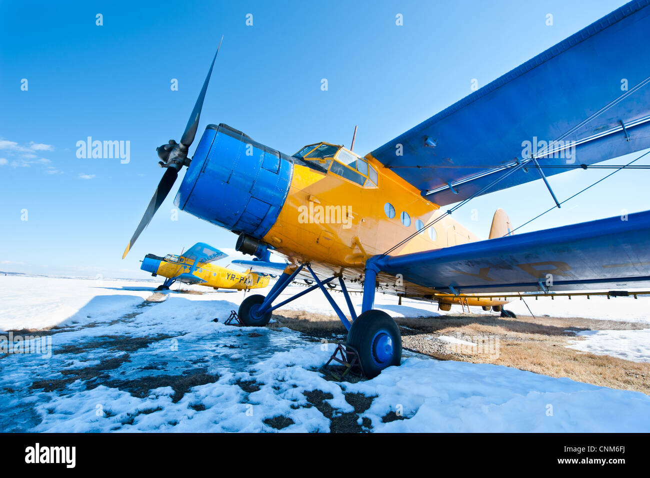 Vecchi aerei parcheggiati su un prato con la neve in una giornata di sole Foto Stock