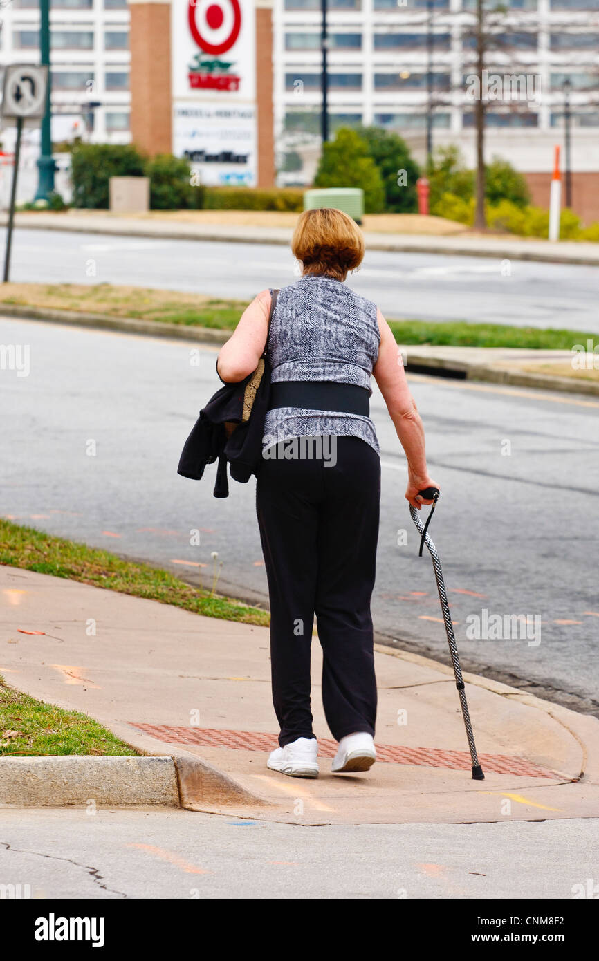 Una donna con un handicap rampa ad un crosswalk Foto Stock