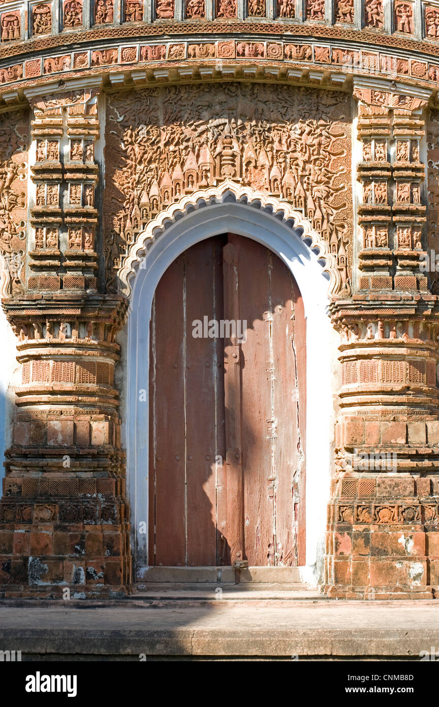 Carving ornati di miti indù al di sopra di una porta, Baranagar, rurale Bengala Occidentale, India, Asia Foto Stock