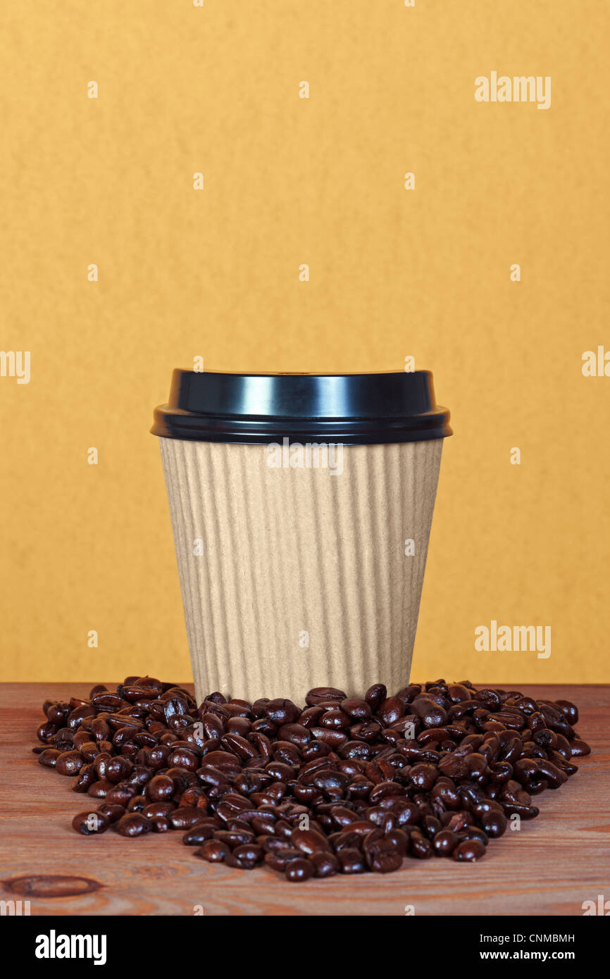Foto di una carta takeway tazza monouso con chicchi di caffè e copiare lo spazio per aggiungere il proprio messaggio. Foto Stock