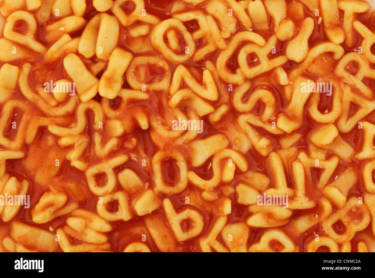Primo piano di alphabet spaghetti al sugo di pomodoro come sfondo e texture Foto Stock