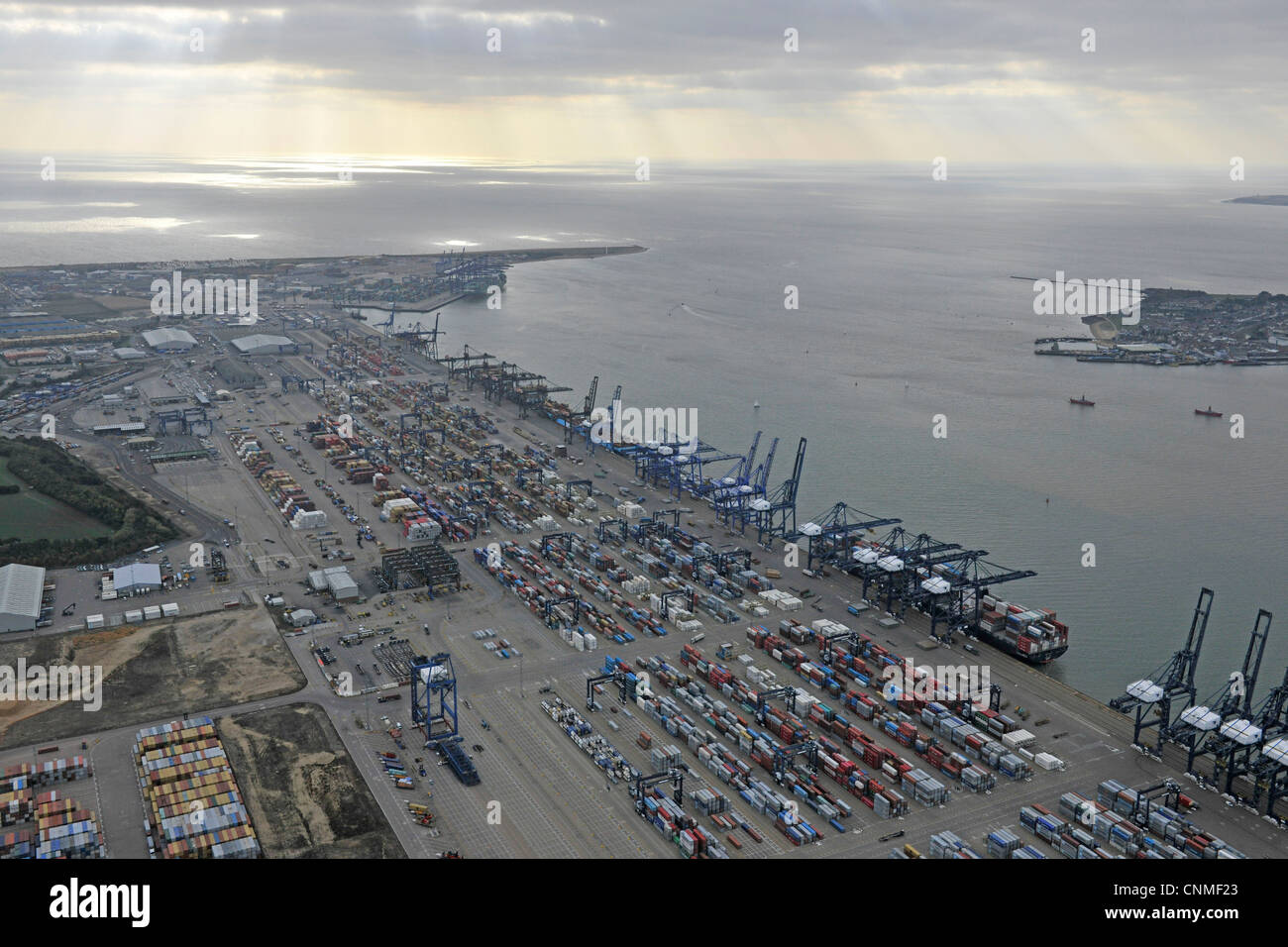 Fotografia aerea mostra Felixtowe Dock con contenitori, gru & navi in dock. La luce del sole proveniente attraverso il cloud. Foto Stock