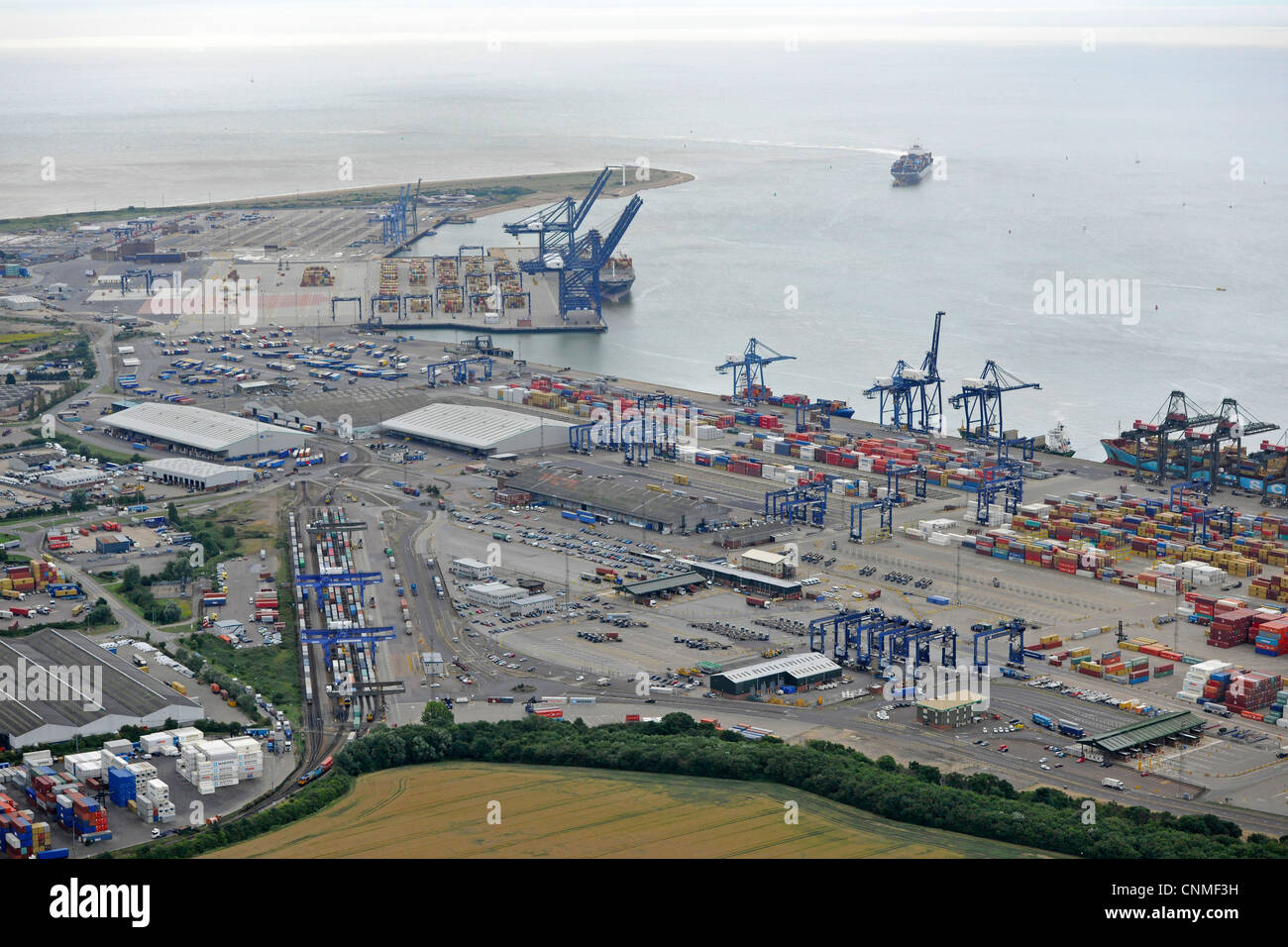Fotografia aerea mostra Felixstowe Docks con contenitori, gru, navi nel dock e in arrivo nel porto. Mostra anche terminale ferroviario Foto Stock