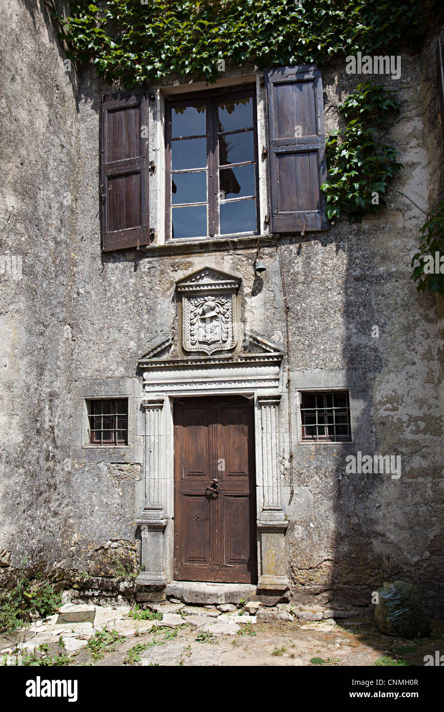 La vecchia porta con stemma di famiglia contenente il casco, Cite de La Couvertoirade, Aveyron, Francia Foto Stock