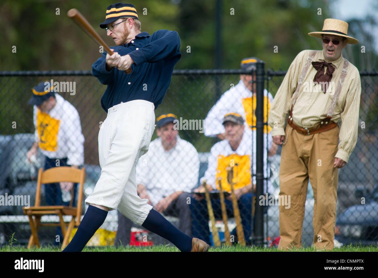 L'uomo fino a bat e arbitro vestito in uniforme vintage vintage a giocare a baseball Foto Stock