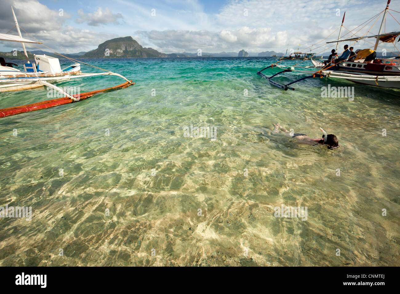 Snorkeller nelle limpide acque off elicottero Isola Arcipelago Bacuit, El Nido, PALAWAN FILIPPINE, Asia Foto Stock