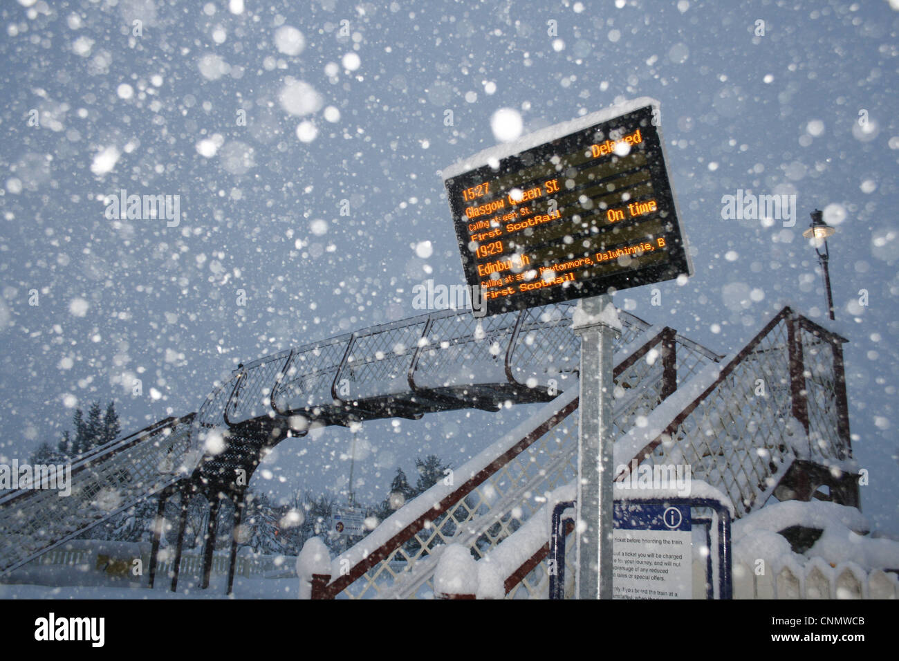 Treno in ritardo' segno alla stazione ferroviaria durante la tempesta di neve Aviemore Station Cairngorms N.P Grampian Mountains Scozia gennaio Foto Stock