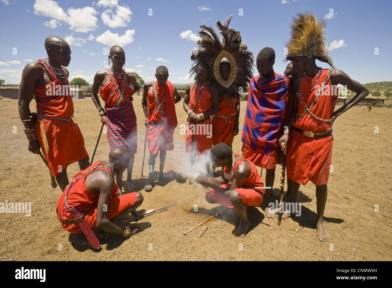 Masai illuminazione tribesmen incendio a bordo del villaggio Masai Mara, Kenya Foto Stock