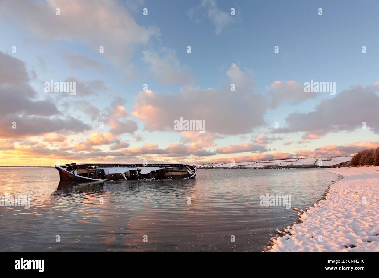 Coperta di neve riverbank relitto vecchio barge parzialmente sommerso in arrivo dal fiume di marea tramonto fiume Taw Fremington molo vicino Heanton Foto Stock