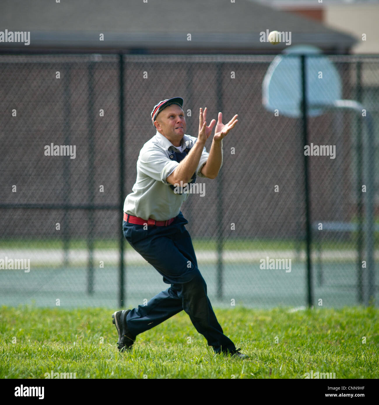 Un uomo vestito in uniforme vintage vintage a giocare a baseball Foto Stock