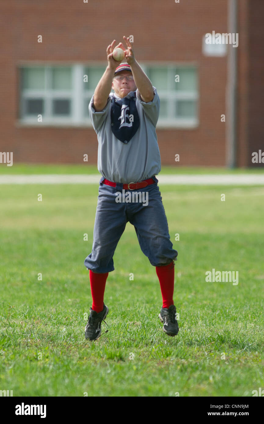 Outfielder cattura la sfera vestito in uniforme vintage vintage a giocare a baseball Foto Stock