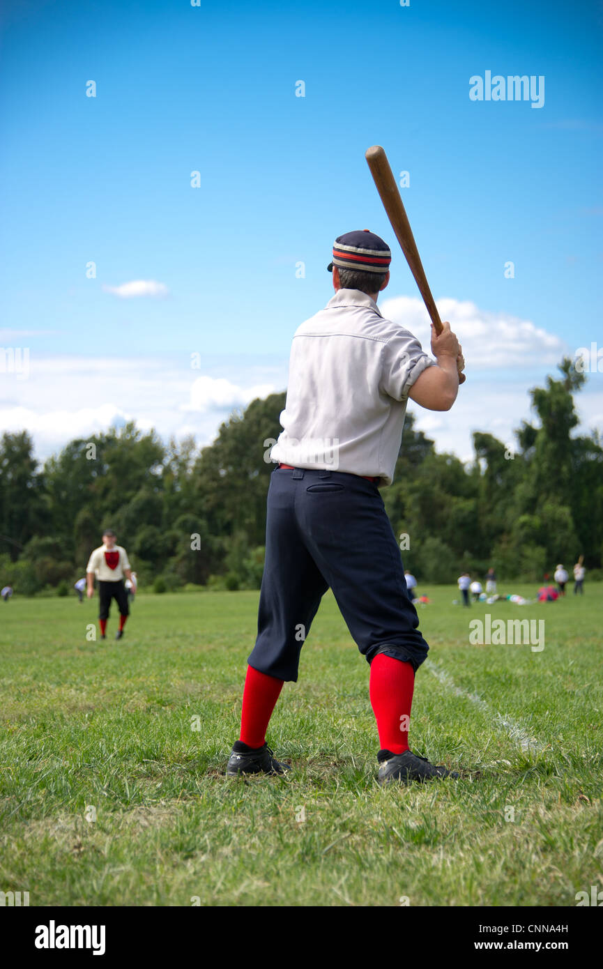 Il compagno di squadra fino a bat e arbitro vestito in uniforme vintage vintage a giocare a baseball Foto Stock