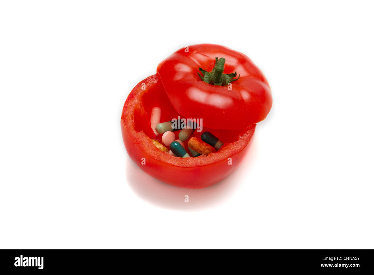 Un pomodoro riempito con le pillole Foto Stock