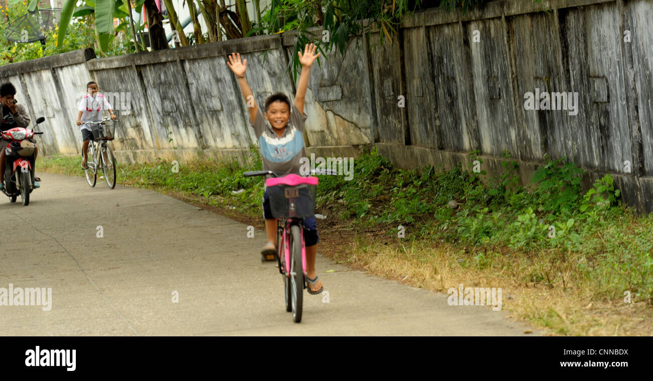 Giovane ragazzo in sella alla sua bicicletta, ko sukon, trang , a sud della Thailandia Foto Stock