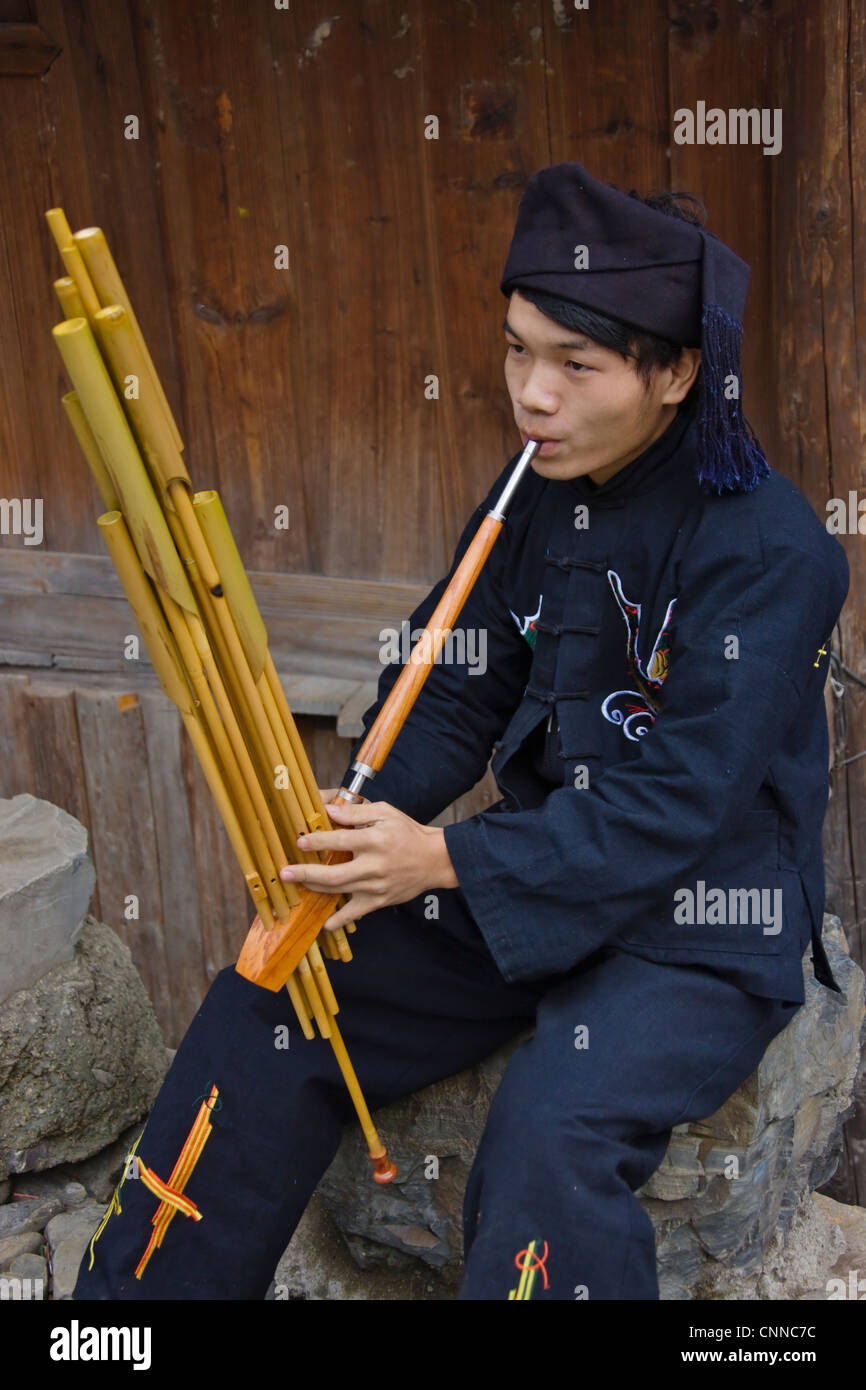 Langde Miao uomo giocando Lusheng, un bambù strumento musicale, Kaili, Guizhou, Cina Foto Stock