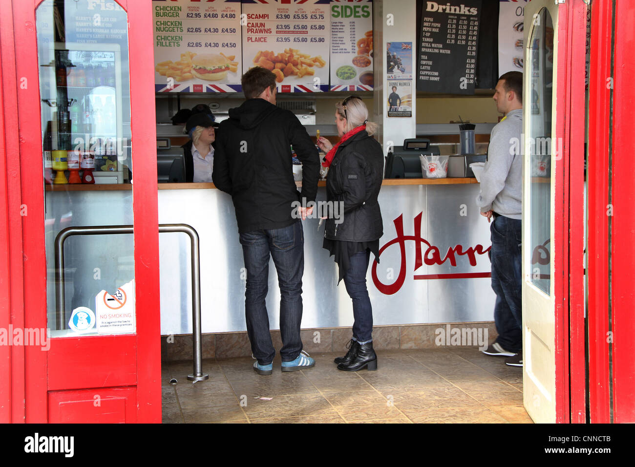 La gente nei pesci e nei chip shop. Foto Stock