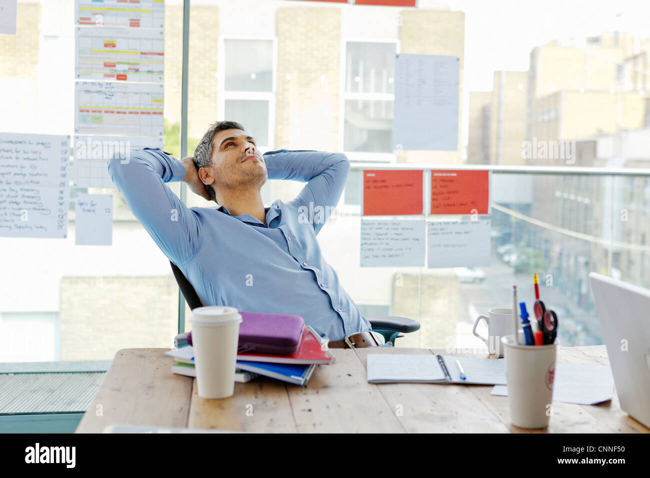 Imprenditore in un momento di relax a scrivania in ufficio Foto Stock