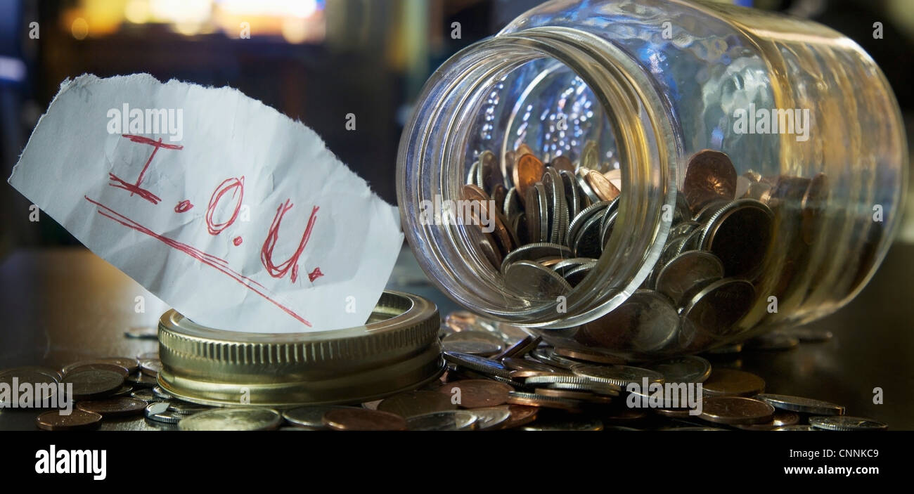 Mason Jar con monete e IOU nota Foto Stock