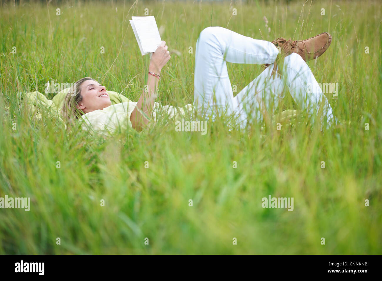 Donna lettura in erba alta Foto Stock