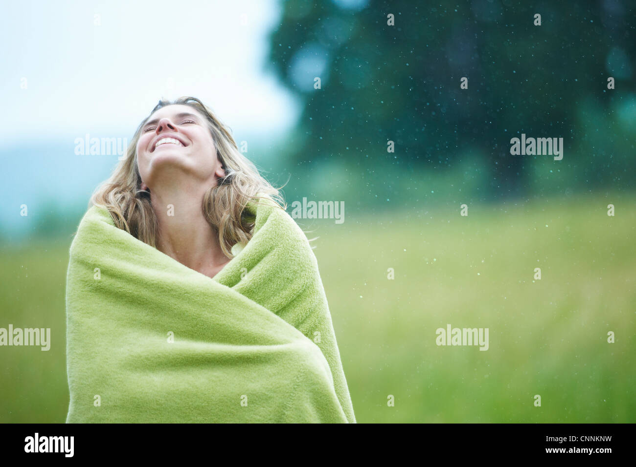 Donna avvolta in una coperta all'aperto Foto Stock