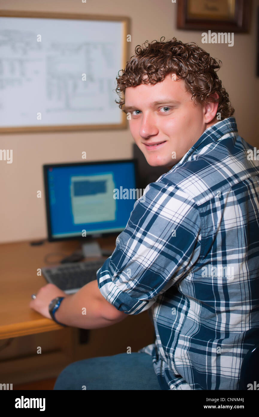 Adolescente di sesso maschile al lavoro sul suo computer Foto Stock