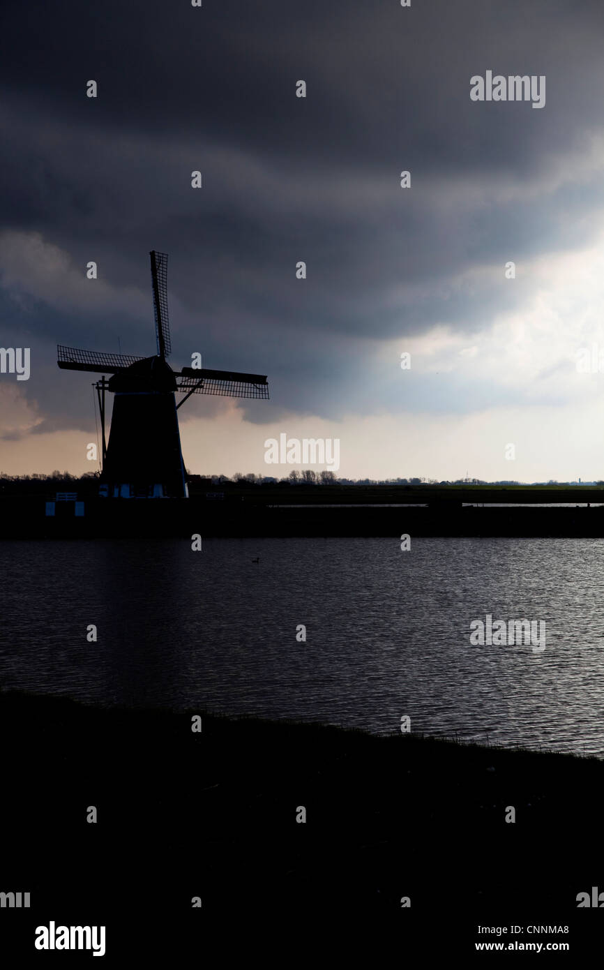 Tipico paesaggio olandese con il mulino a vento e cielo tempestoso, Texel, Isole Frisone in mare di Wadden, Holland, Paesi Bassi, Europa Foto Stock