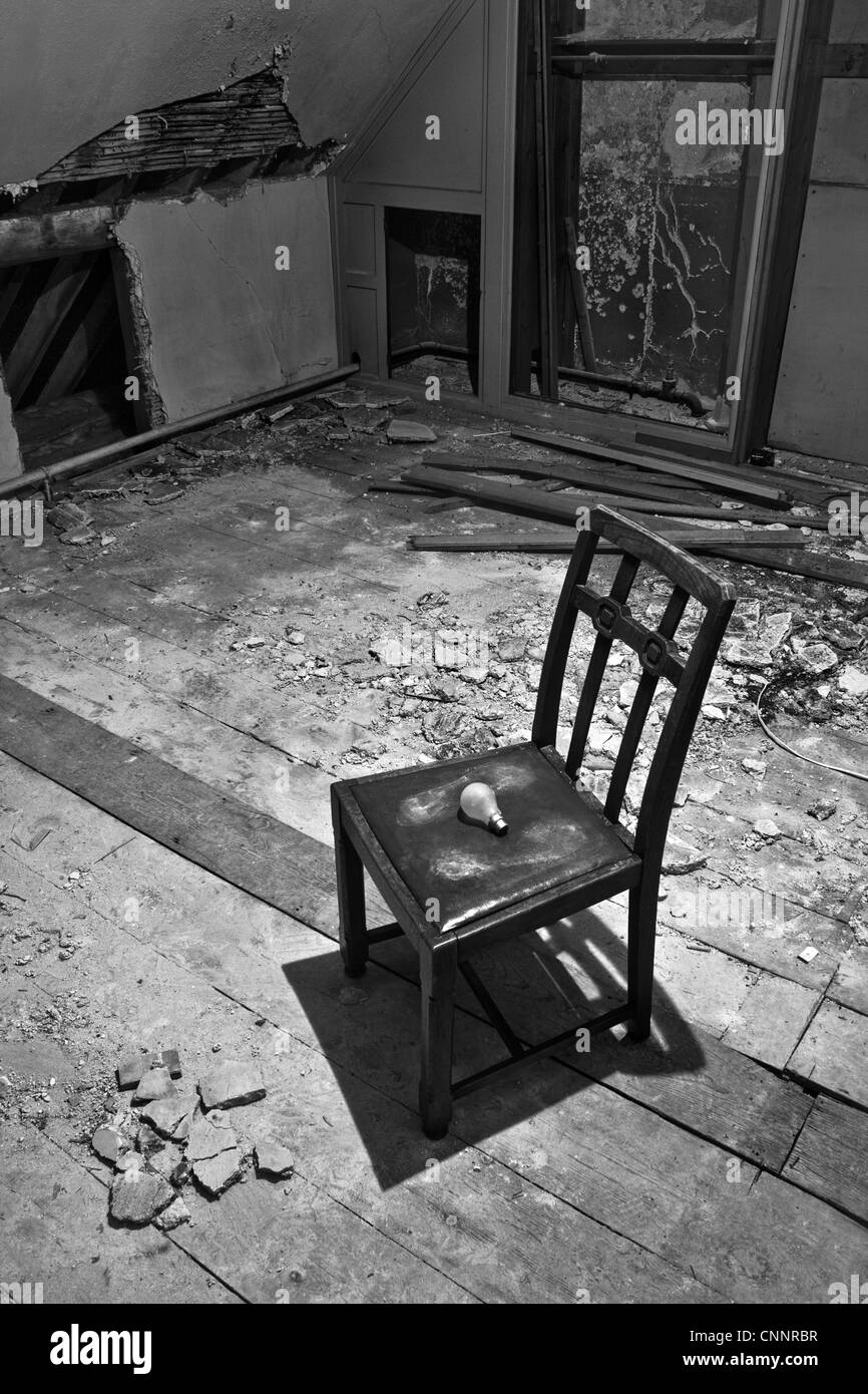 Una vecchia camera abbandonati con una vecchia sedia in legno con ingombro e una lampadina. Chi ha cambiato che lampadina? Foto Stock