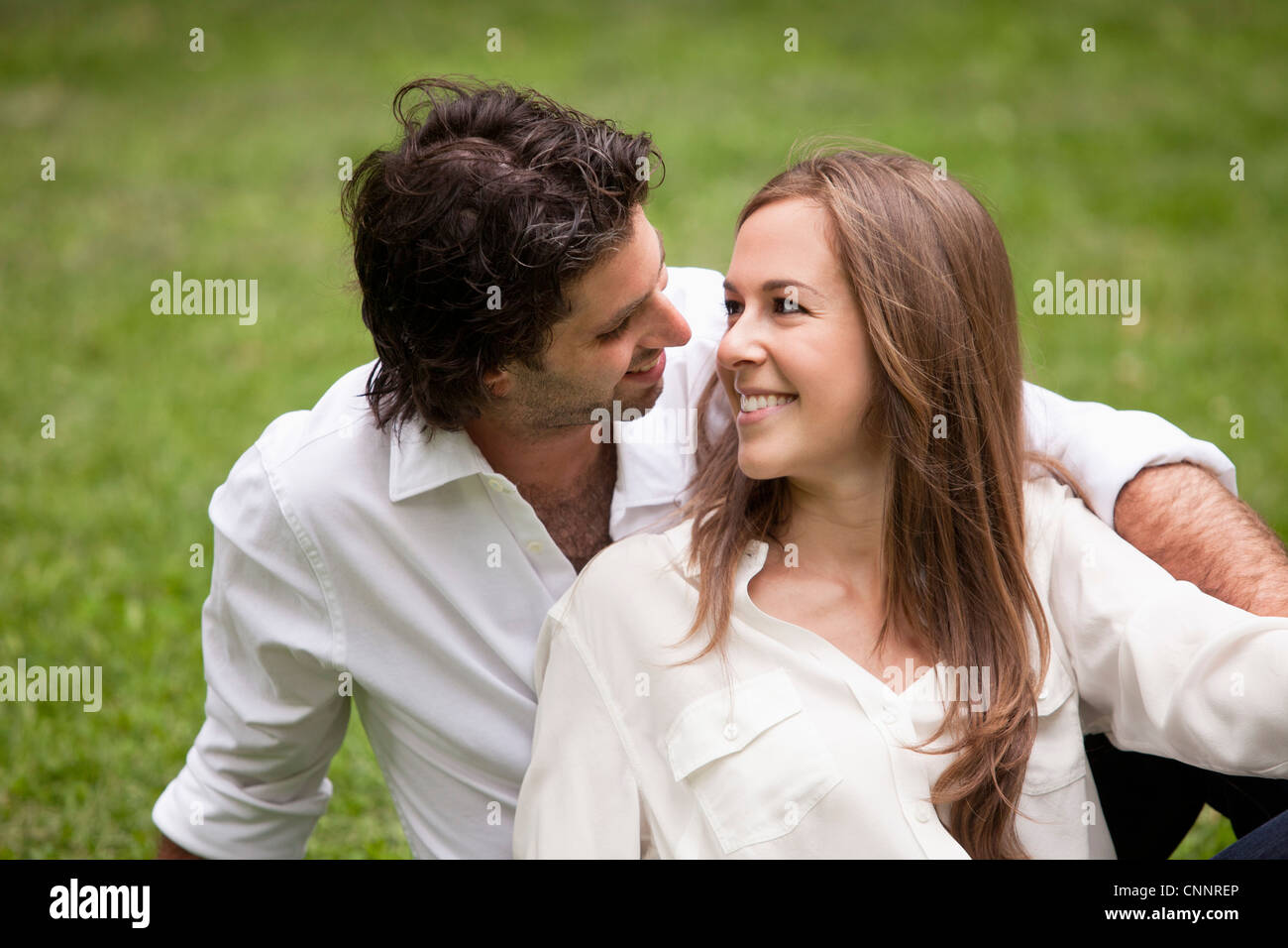 Close-up ritratto della coppia giovane seduto sull'erba in posizione di parcheggio Foto Stock