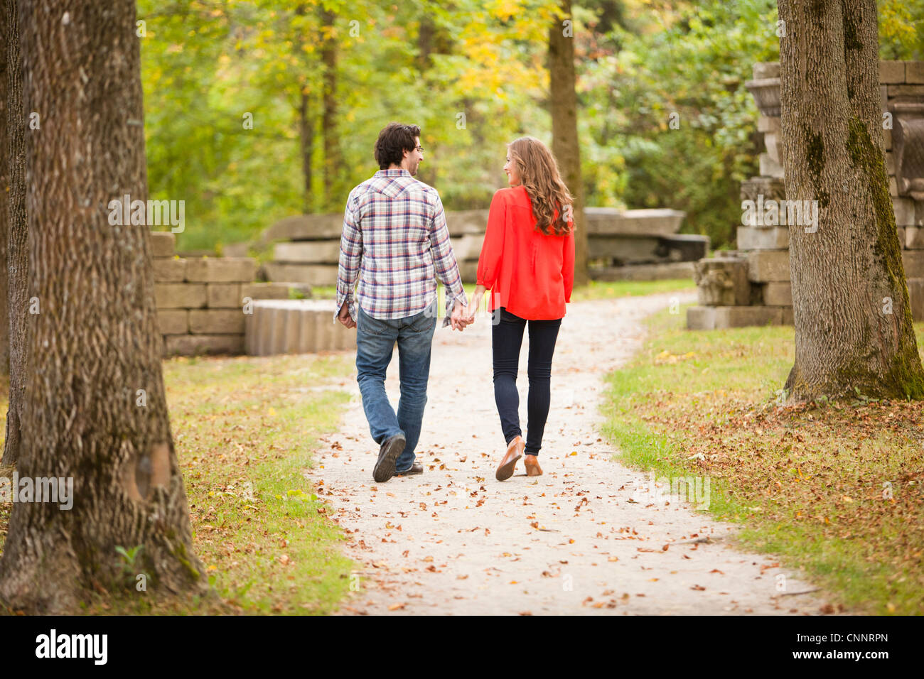 Backview di coppia giovane a piedi attraverso il Parco in autunno, Ontario, Canada Foto Stock