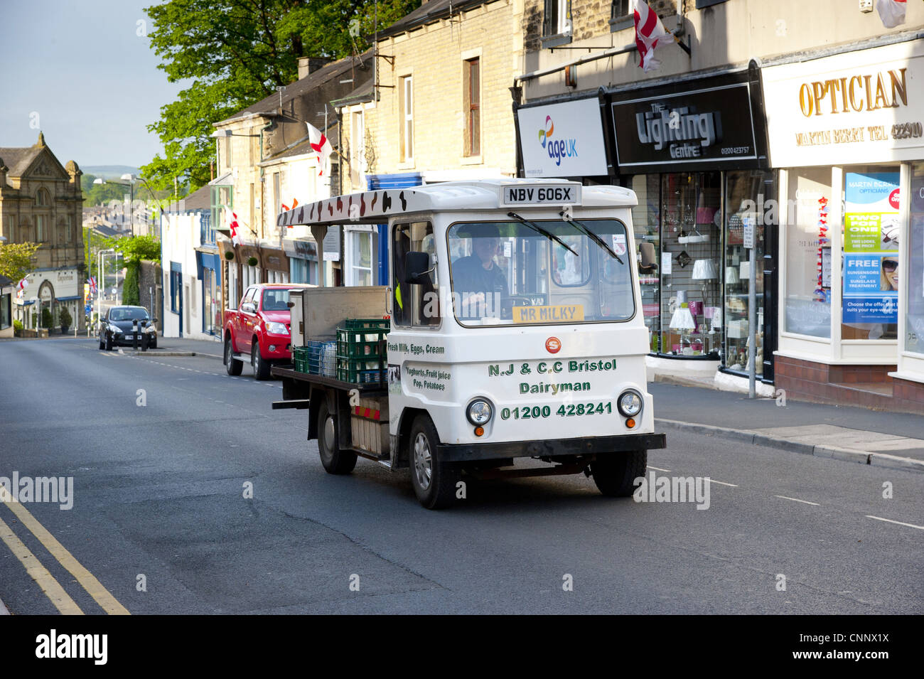 Latte elettrico galleggiante fornendo in città, Clitheroe, Lancashire, Inghilterra, può Foto Stock