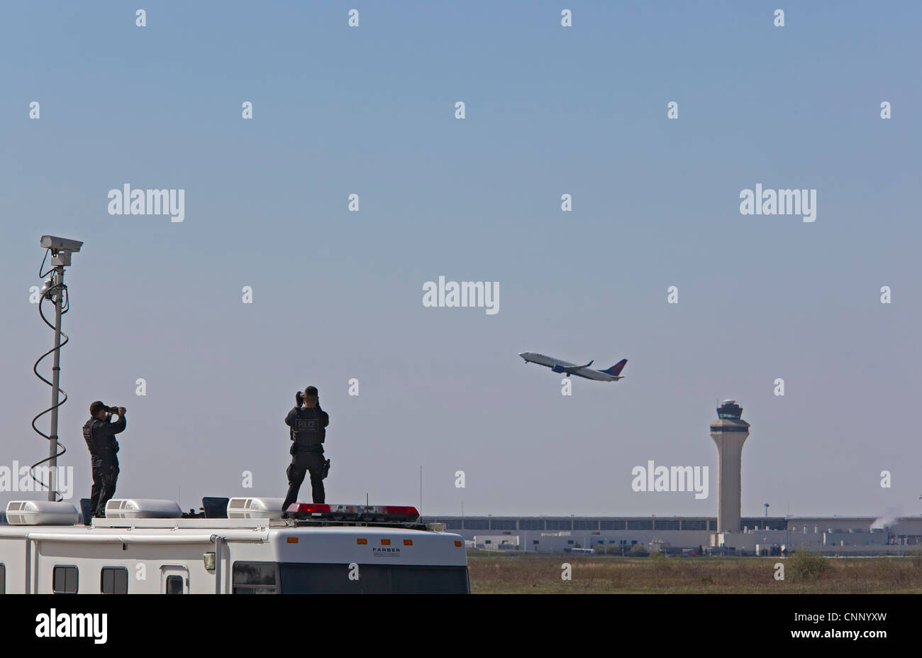 Agenti dei servizi segreti con il binocolo cercare le minacce prima che il Presidente Obama l'arrivo all'Aeroporto Metro di Detroit su Air Force 1. Foto Stock