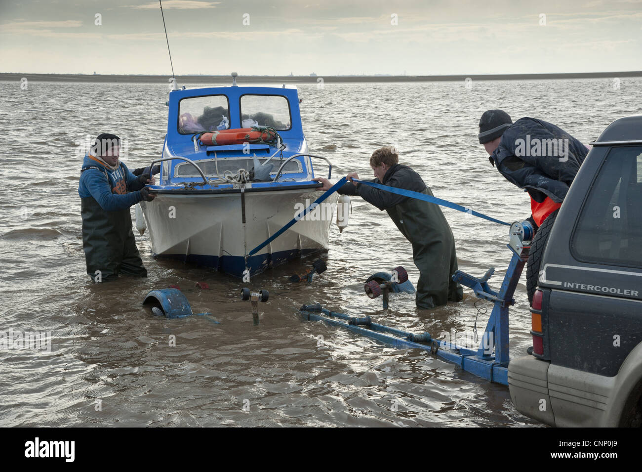 Licenza raccoglitrici di arricciatura sbarco barca lo scarico dopo la raccolta cockle letti Banca Foulnaze tra Lytham Southport Ribble Estuary Foto Stock