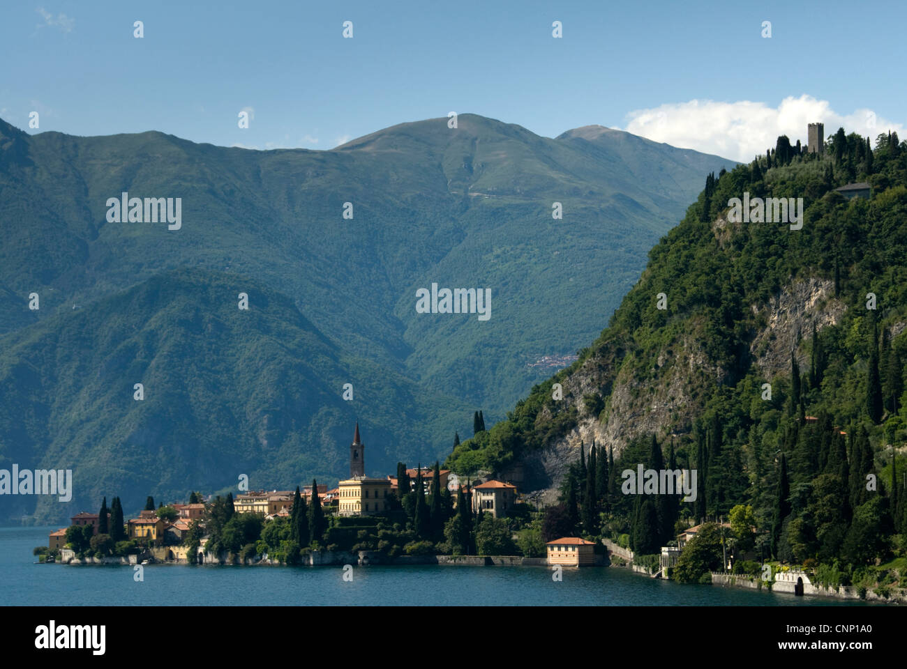 Il comune di Varenna si accoccola accanto al lago di Como, vegliato dal Castello de Vezio, Italia. Foto Stock