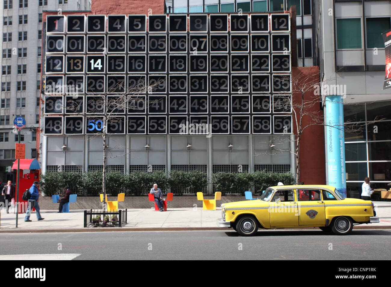 Giallo iconico New York taxi parcheggiato di fronte a un gigantesco orologio a Manhattan. Stati Uniti d'America Foto Stock