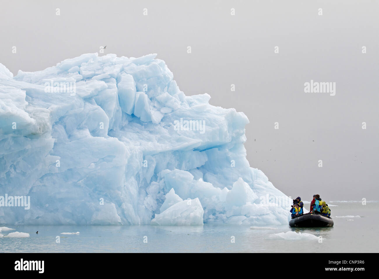I turisti fotografare iceberg dal Zodiac gommone, Spitzbergen, Svalbard, luglio Foto Stock
