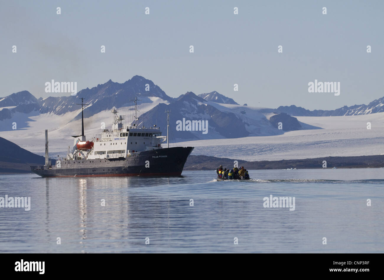 Zodiac barca gonfiabile con turisti avvicinando la nave di crociera, con ghiacciaio in background, Spitzbergen, Svalbard, luglio Foto Stock