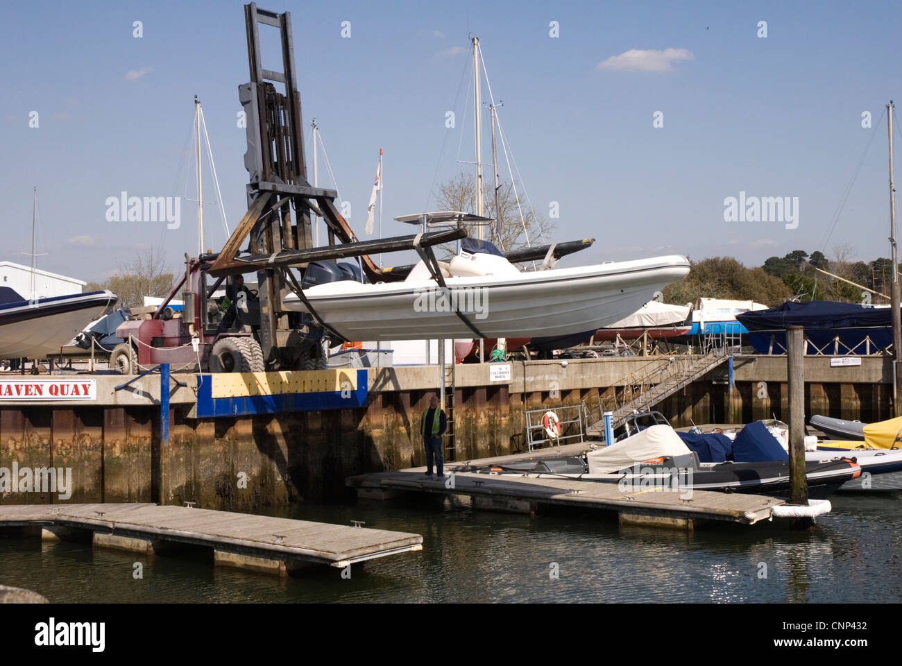 Lymington - Hants - Haven Quay - lancio di una barca a motore - Carrello elevatore a forca con portata estesa - Luce solare - cielo blu Foto Stock