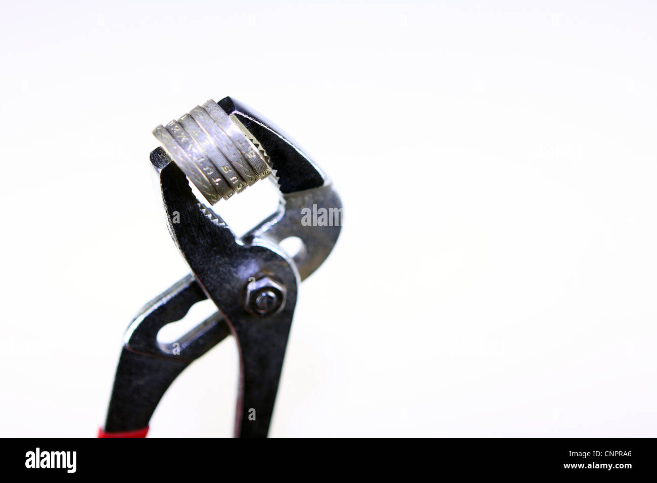 Sterling £1 monete tra le ganasce di una chiave Foto Stock