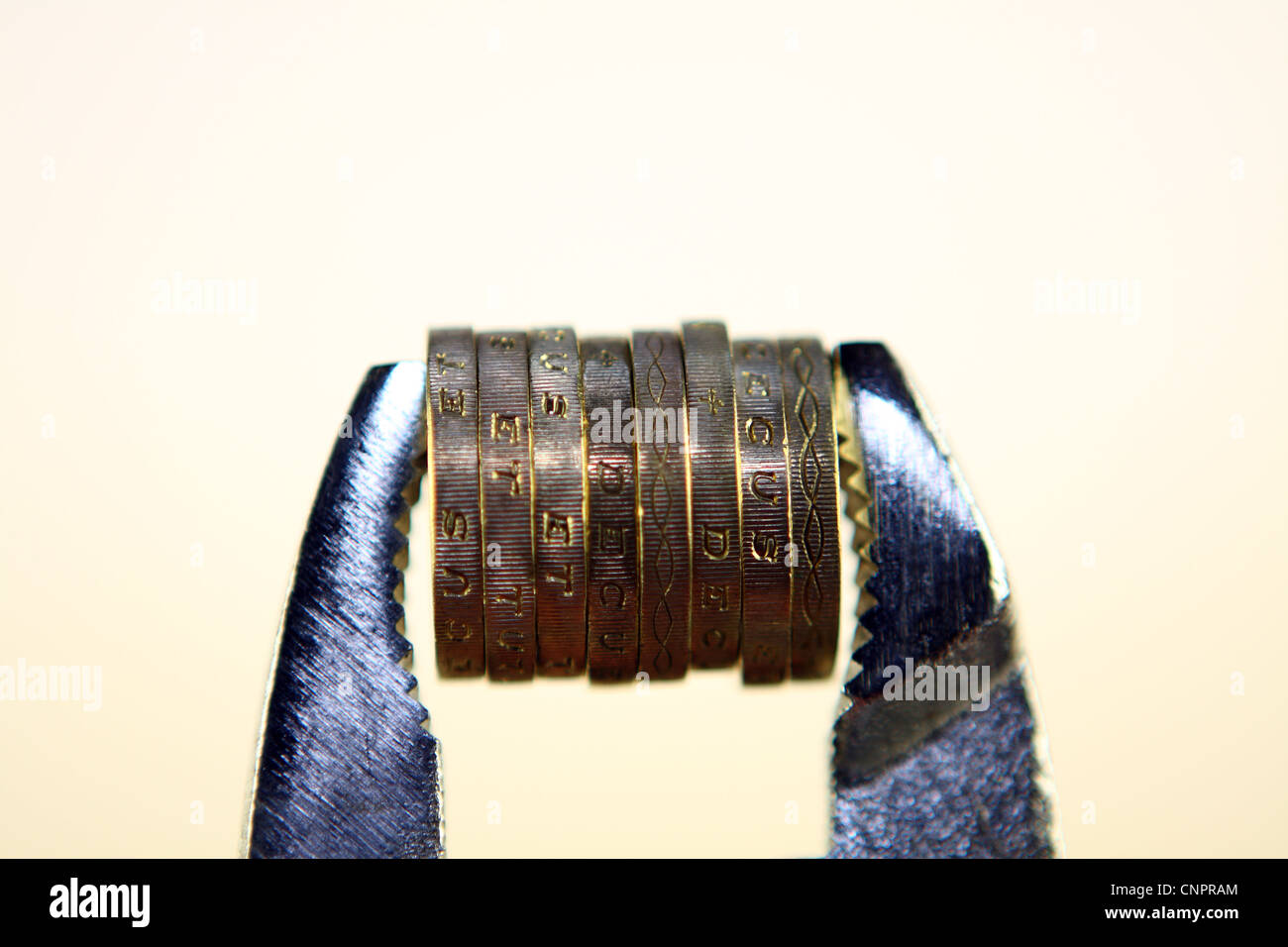 Sterling £1 monete tra le ganasce di una chiave Foto Stock