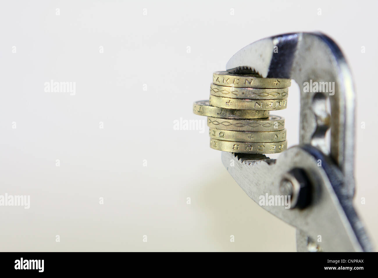 Sterling £1 monete tra le ganasce di una chiave Foto Stock