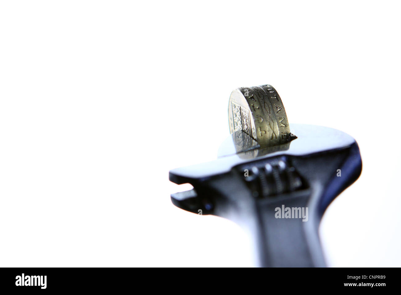 Sterling £1 monete tra le ganasce di una chiave Foto Stock