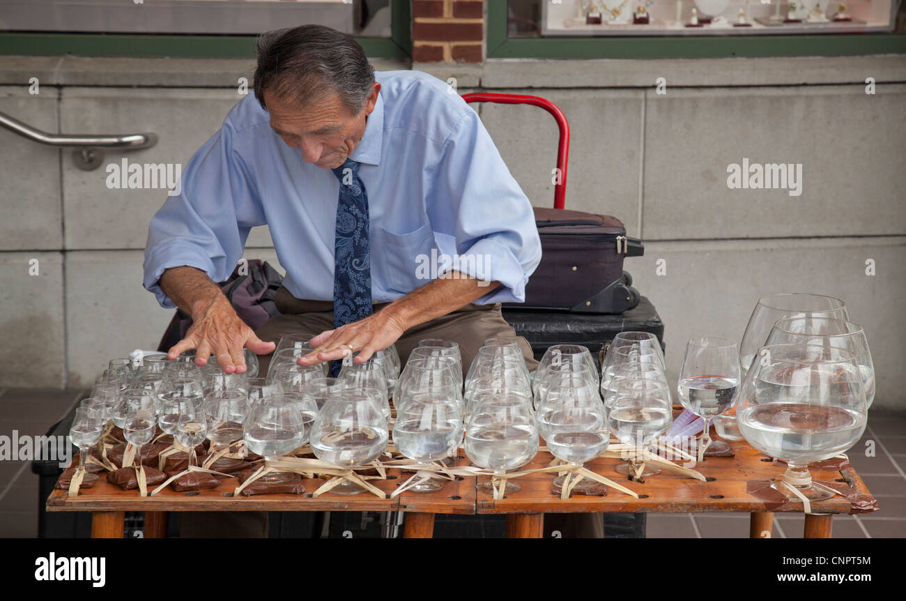 Uomo a fare musica con bicchieri di acqua Foto Stock